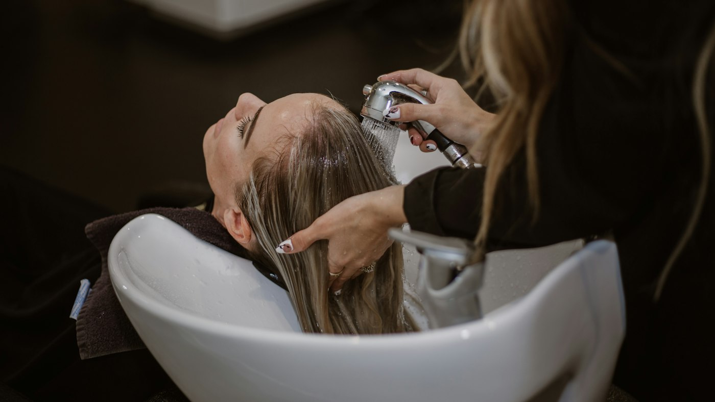 A salon client having her hair cut by a stylist