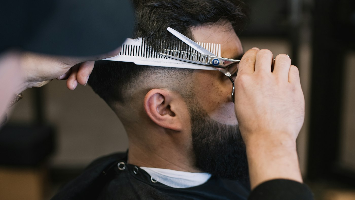 A barber cutting a regular customer's hair