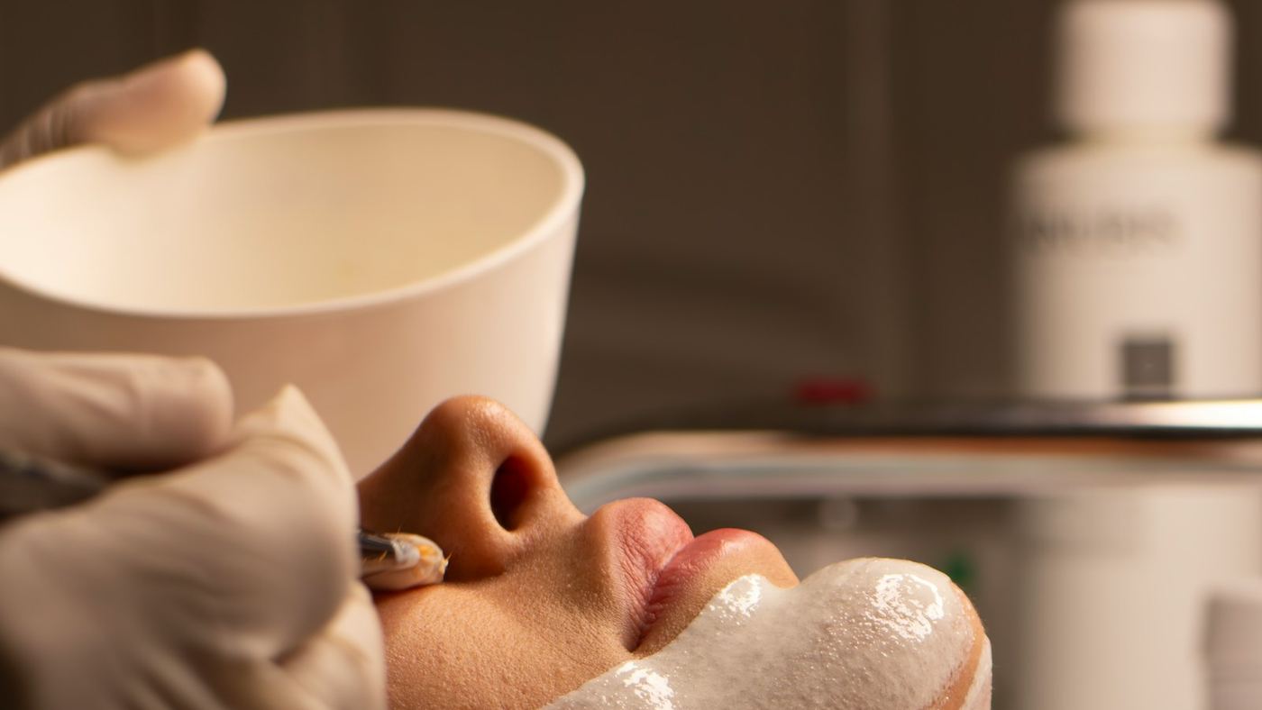 A client having a facial treatment applied by a beauty therapist