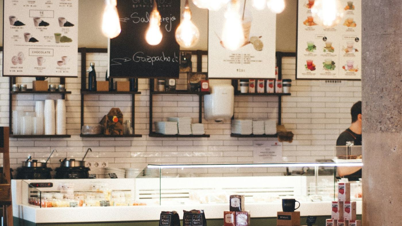 The service counter of a café, with menu boards and pendant lighting above