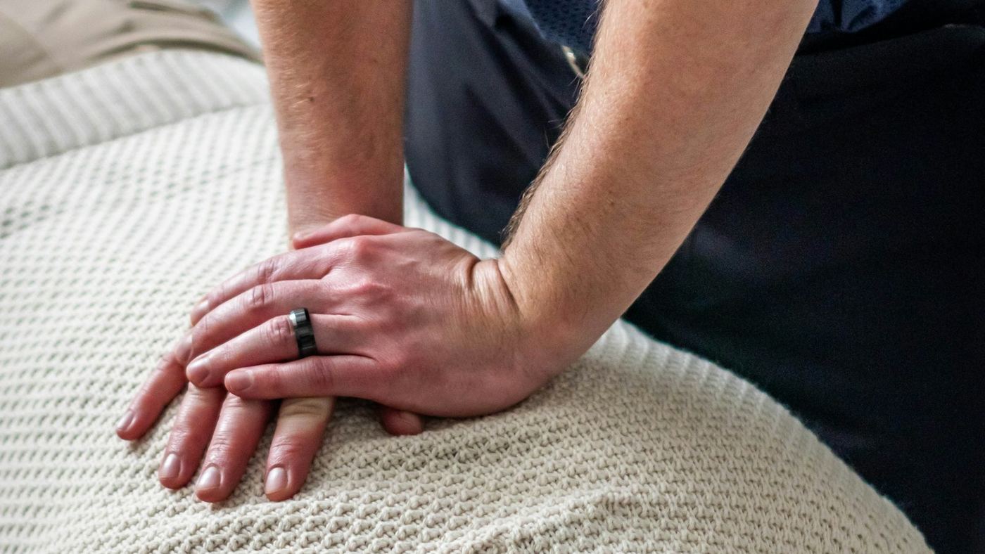 A therapist performing a manual treatment on a client lying on a treatment couch